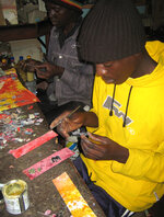 Ein junger Mitarbeiter bei Dangwe Arts formt Tiere aus Draht als Dekoration für Karten.